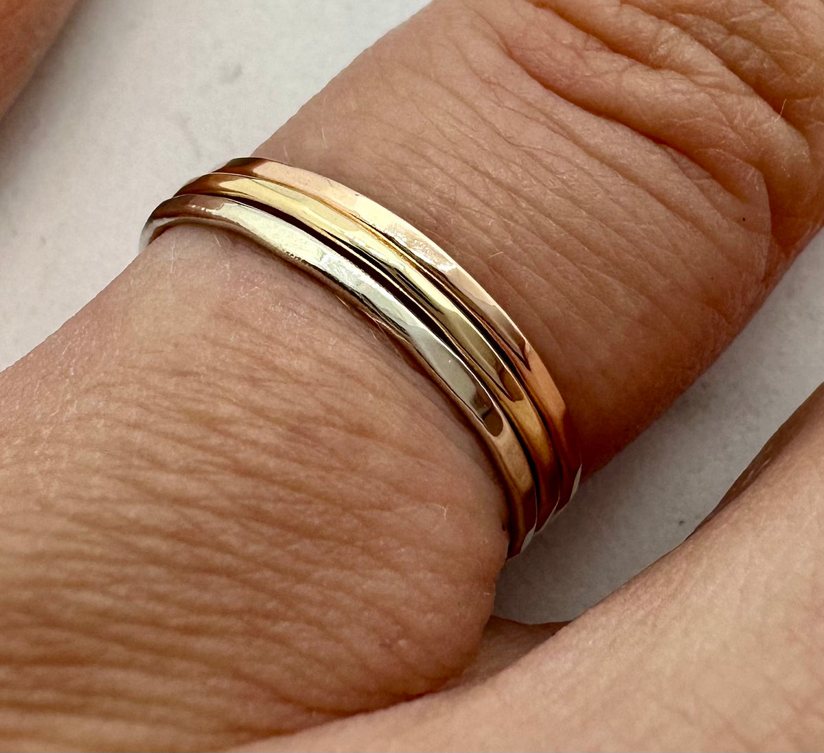 9ct gold hammered stacking ring stacked with other rings