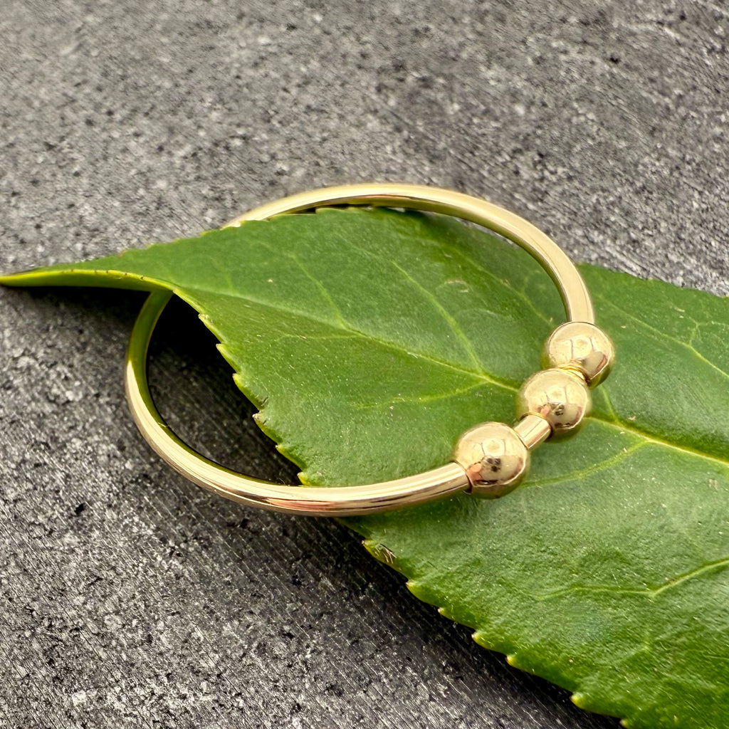 9ct gold bead fidget ring stacked with other rings
