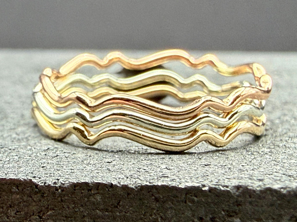 9ct gold wavy stacking ring on hand, side angle