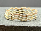 9ct gold wavy stacking ring on hand, side angle