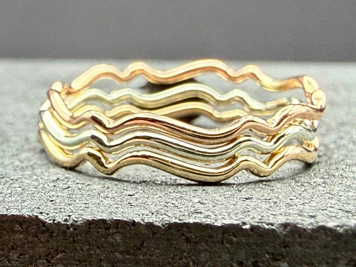 9ct gold wavy stacking ring on hand, side angle