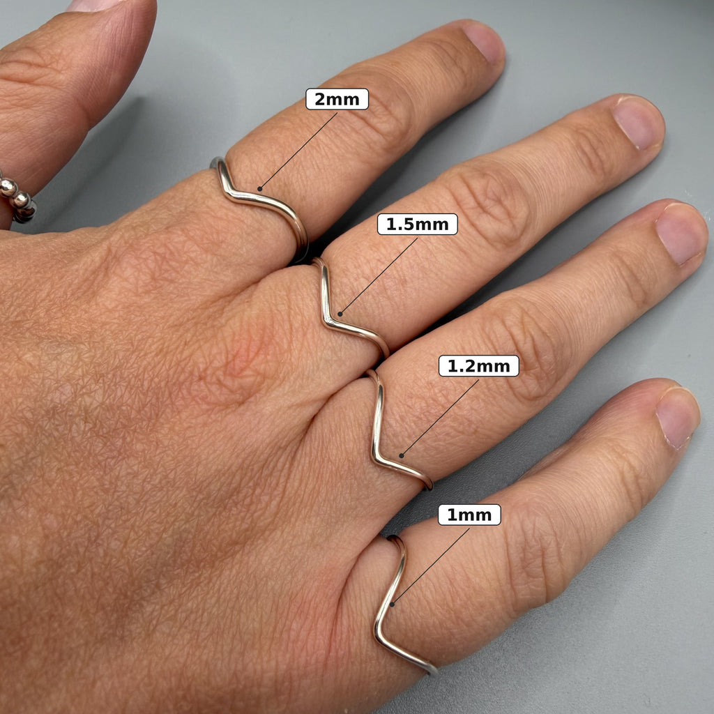 Sterling silver wishbone ring worn on hand with size guide