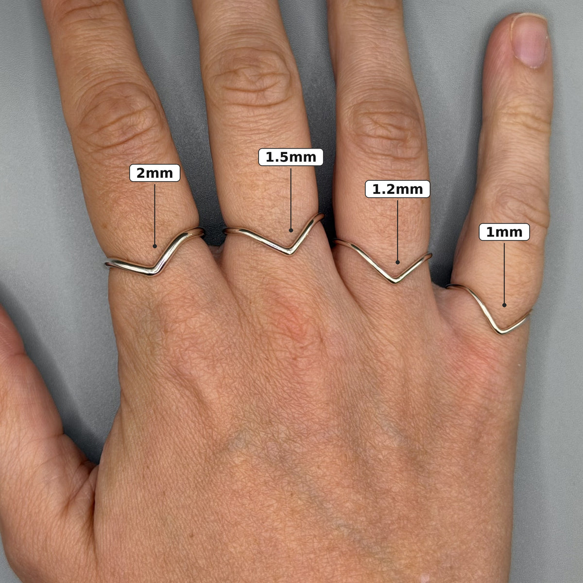 Sterling silver wishbone ring worn on hand, size labelled